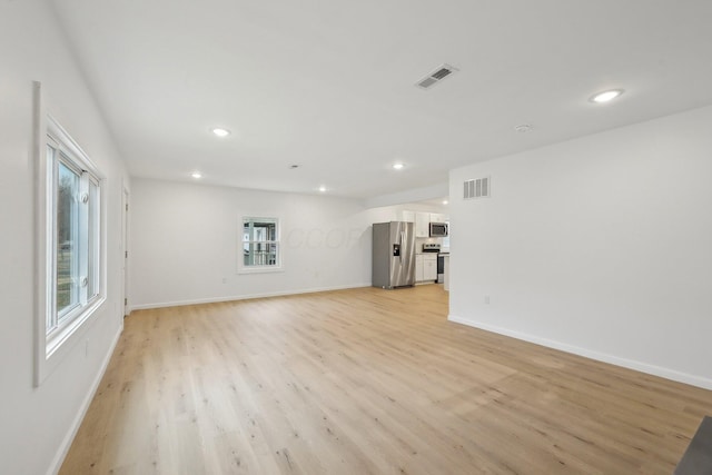 unfurnished living room featuring light wood-type flooring, visible vents, baseboards, and recessed lighting