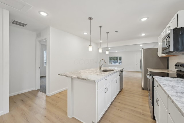 kitchen with light wood-type flooring, white cabinetry, stainless steel appliances, and a sink