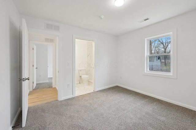 unfurnished bedroom featuring carpet floors, visible vents, and baseboards