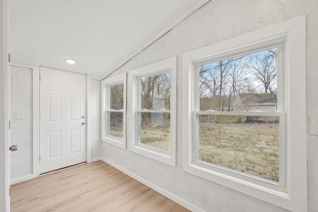 interior space with lofted ceiling, wood finished floors, and baseboards