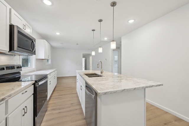 kitchen with decorative backsplash, stainless steel appliances, light wood-type flooring, and a sink
