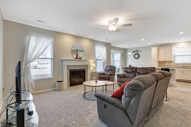 living area with visible vents, a ceiling fan, recessed lighting, baseboards, and a tile fireplace