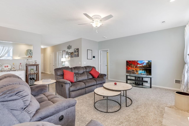 living area featuring carpet flooring, baseboards, visible vents, and ceiling fan