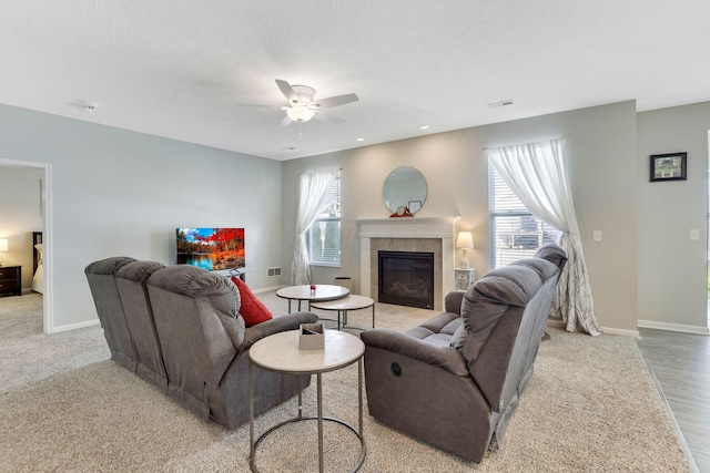 living area with visible vents, baseboards, ceiling fan, and a fireplace