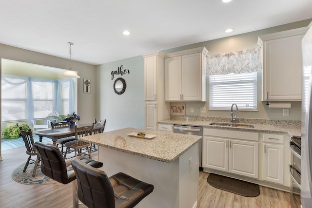 kitchen featuring light stone counters, recessed lighting, light wood-type flooring, and a sink