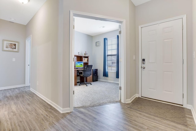 entryway featuring baseboards and wood finished floors