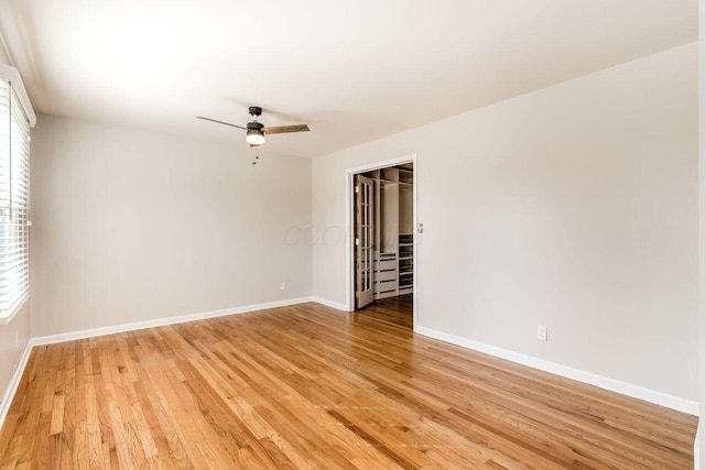 unfurnished room featuring baseboards, light wood-style floors, and ceiling fan