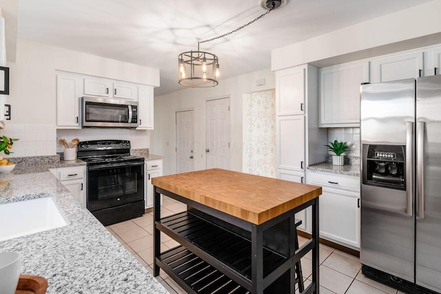 kitchen featuring white cabinetry, light tile patterned floors, tasteful backsplash, and appliances with stainless steel finishes