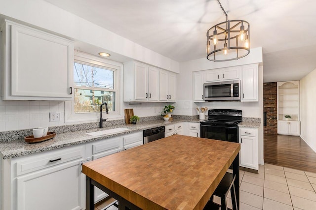 kitchen featuring a sink, tasteful backsplash, white cabinetry, stainless steel appliances, and light tile patterned floors