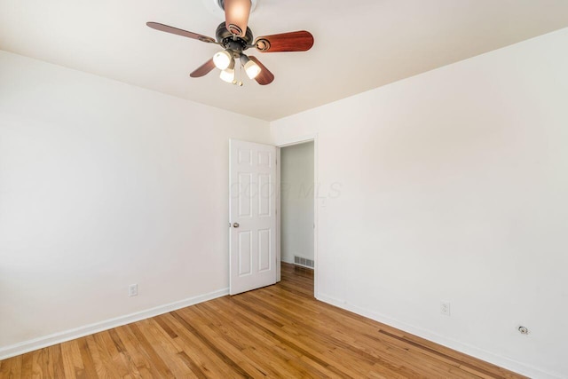 spare room with a ceiling fan, light wood-style flooring, baseboards, and visible vents