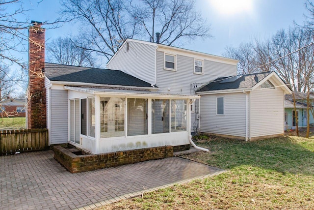 rear view of property with a patio, fence, a chimney, and a sunroom