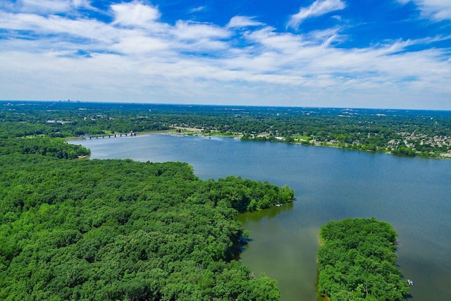 aerial view featuring a wooded view and a water view