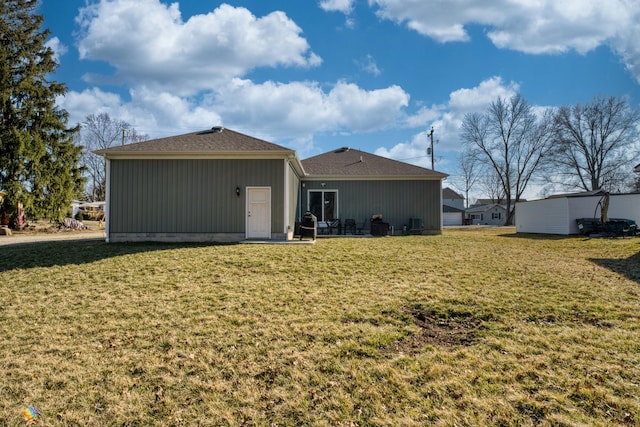 back of house with a lawn and a patio