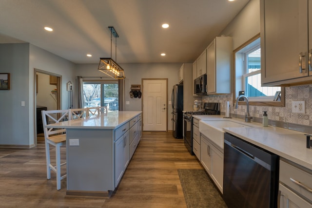 kitchen featuring a kitchen island, appliances with stainless steel finishes, a breakfast bar, and light countertops