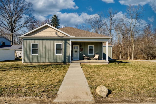 view of front of home with roof with shingles, a porch, and a front lawn