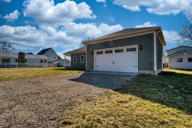 view of front facade featuring board and batten siding, gravel driveway, a front lawn, and fence