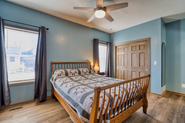 bedroom featuring multiple windows, visible vents, and light wood finished floors