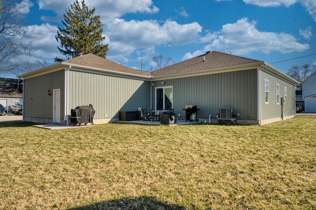 rear view of house with a patio, central air condition unit, a lawn, and roof with shingles