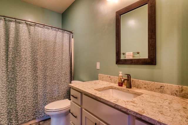 full bathroom with toilet, vanity, and a textured ceiling