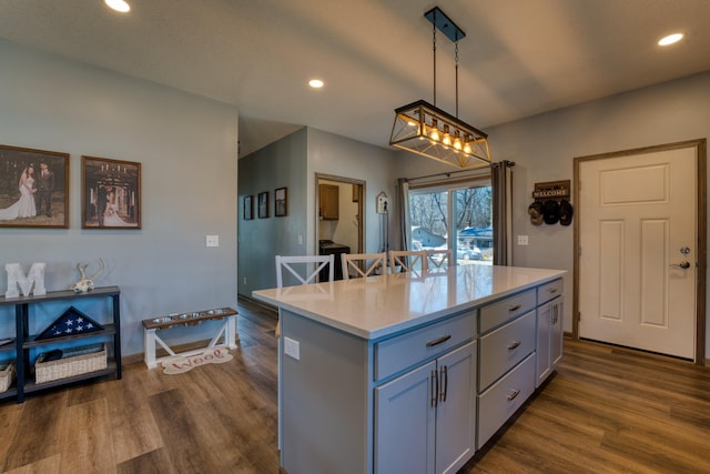 kitchen with decorative light fixtures, gray cabinetry, light countertops, and dark wood-style flooring