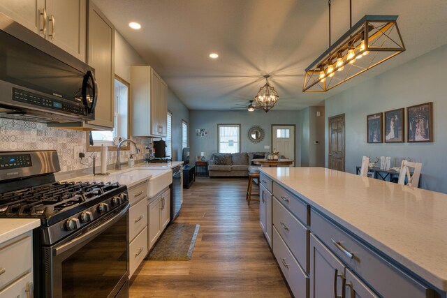 kitchen with dark wood finished floors, plenty of natural light, open floor plan, and stainless steel range with gas cooktop