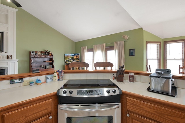 kitchen with light countertops, lofted ceiling, and stainless steel range with electric cooktop