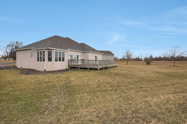 back of house with a shingled roof, a lawn, a wooden deck, and stucco siding