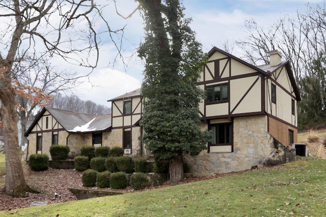 view of home's exterior featuring a yard, a chimney, and stucco siding