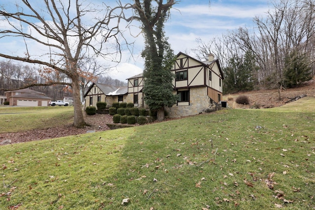 view of side of property with stone siding, a chimney, a lawn, and stucco siding