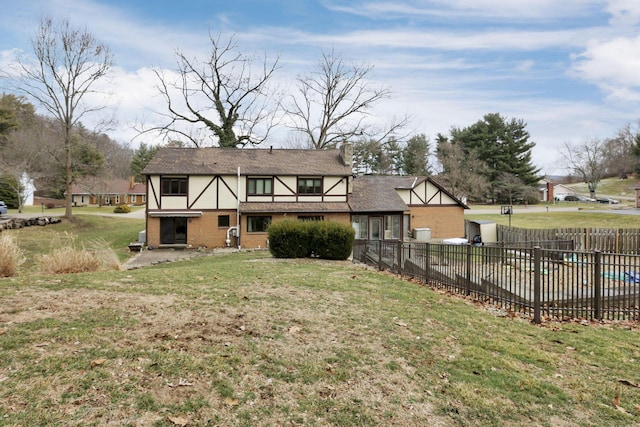 rear view of house with a patio area, fence, a covered pool, and a lawn