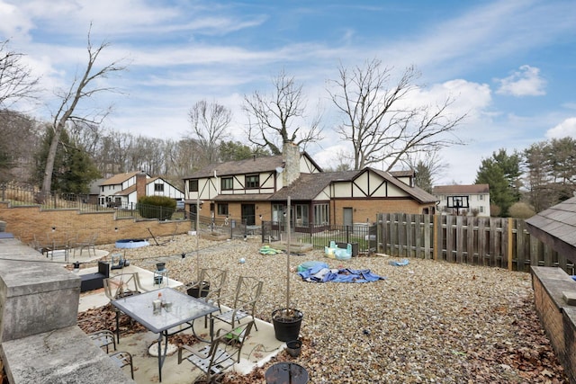 back of house with fence private yard, outdoor dining space, a chimney, and a patio