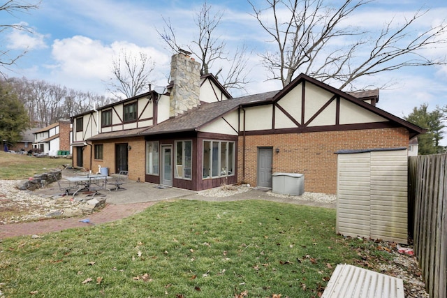 back of house featuring brick siding, a yard, a patio, stucco siding, and fence