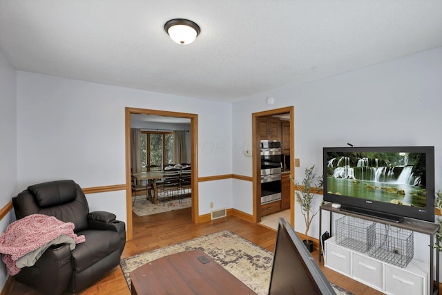 office space with light wood-type flooring, baseboards, and visible vents