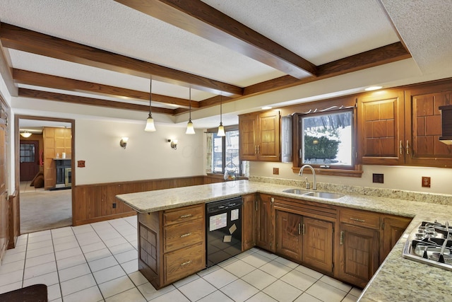 kitchen with wainscoting, a sink, a textured ceiling, dishwasher, and a peninsula