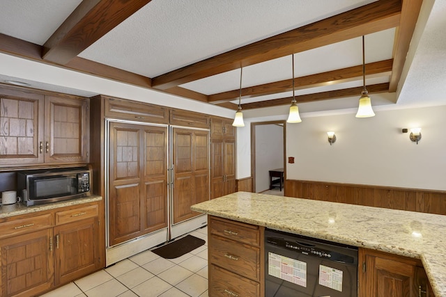 kitchen featuring black dishwasher, brown cabinets, beam ceiling, light tile patterned floors, and wainscoting