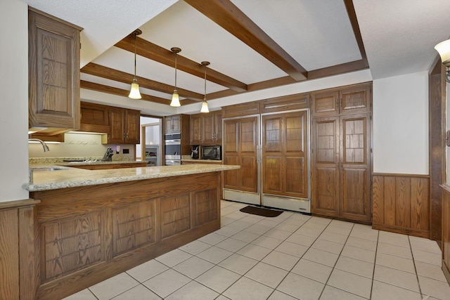 kitchen with built in microwave, beam ceiling, a wainscoted wall, and a sink