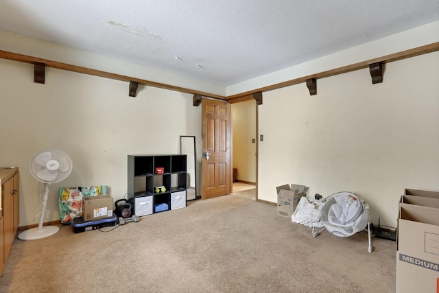 interior space featuring carpet floors, a textured ceiling, baseboards, and beamed ceiling