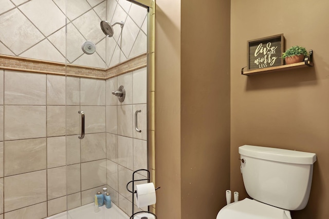 bathroom with a shower stall and toilet