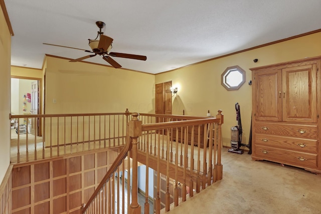 corridor with ornamental molding, light carpet, and an upstairs landing