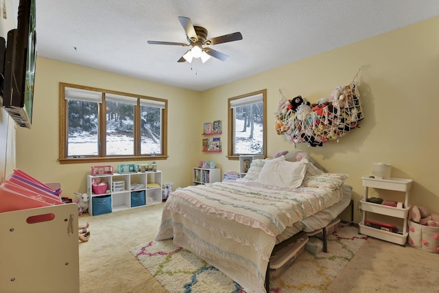 bedroom featuring a textured ceiling, ceiling fan, and carpet