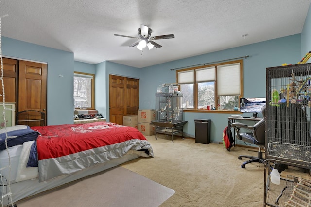 carpeted bedroom with a textured ceiling and ceiling fan