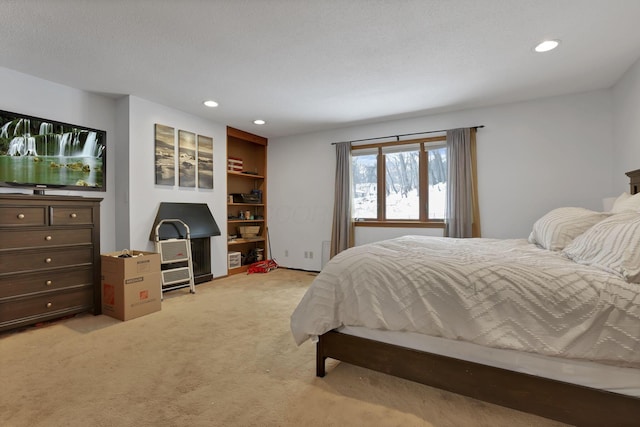 bedroom with recessed lighting, light carpet, and a textured ceiling