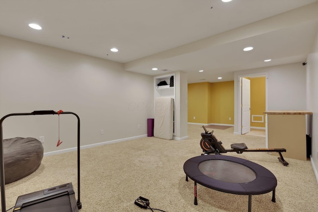 exercise area with recessed lighting, light colored carpet, and baseboards