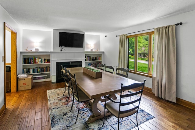 671 Carriage Ct, Newark, OH 43055 - dining room featuring hardwood / wood-style flooring, a fireplace with flush hearth, and a textured ceiling