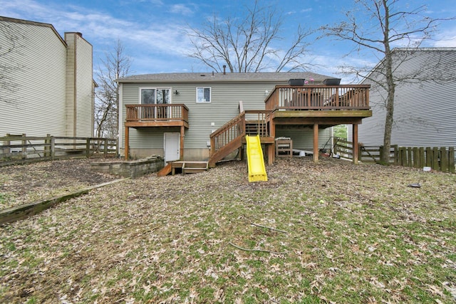 rear view of house featuring stairway, fence, and a deck