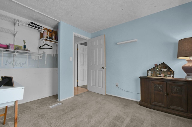 carpeted bedroom with a textured ceiling and baseboards