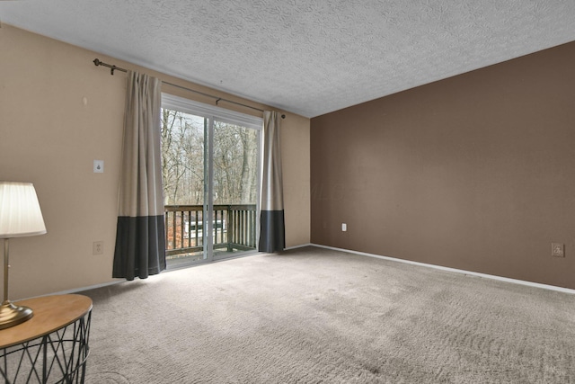 unfurnished room featuring a textured ceiling, carpet flooring, and baseboards