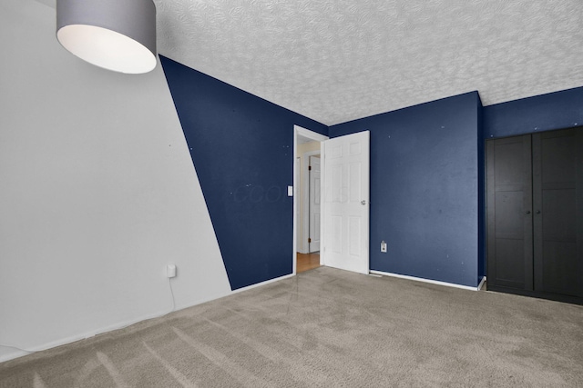 unfurnished bedroom featuring carpet floors, a closet, and a textured ceiling