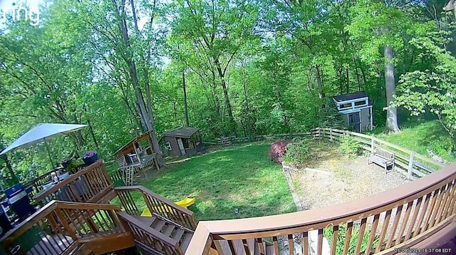 view of yard with a forest view, fence, and an outbuilding