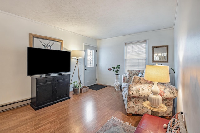 living room featuring crown molding, baseboards, light wood-style floors, a textured ceiling, and a baseboard radiator